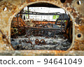 Damaged and destroyed civilian car with shrapnel holes from Russian missile in a war zone in Kharkiv, Ukraine 94641049