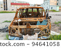 Damaged and destroyed civilian car with shrapnel holes from Russian missile in a war zone in Kharkiv, Ukraine 94641058