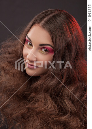 Close-up portrait, girl with long curly hair and red shades for eyes Close-up portrait, girl with long curly hair and red shades for eyes 94641255