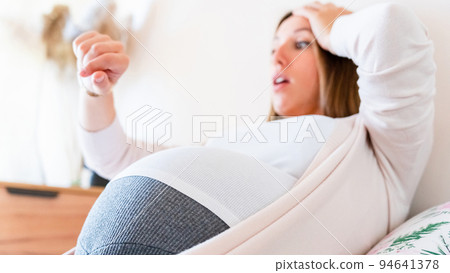 Pregnant pain contractions. Pregnant woman watching clock, holding baby belly. Childbirth time, contractions pain. Pregnancy, medicine health care concept. 94641378