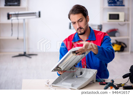 Young male repairman repairing heater Young male repairman repairing heater 94641657