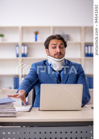 Young male employee after accident sitting at workplace 94641692