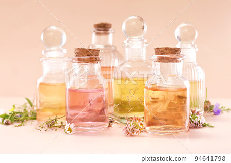 Colorful essential oil bottles and medicinal herbs background, selective focus, shallow DOF, toned Colorful essential oil bottles and medicinal herbs background, selective focus, shallow DOF, toned 94641798