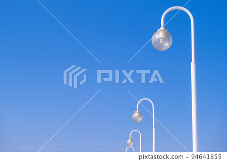 Street lights at daytime on blue sky background. Creative abstract pattern photo. Round Street lamps. energy saving concept. Copy space  94641855