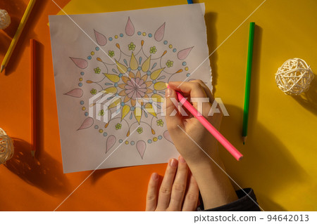 Female painting mandalas antistress page to combat stress. Relaxing hobby mental wellbeing and art therapy. Woman paints sketch, meditative process of coloring pages. Self expression by art  94642013