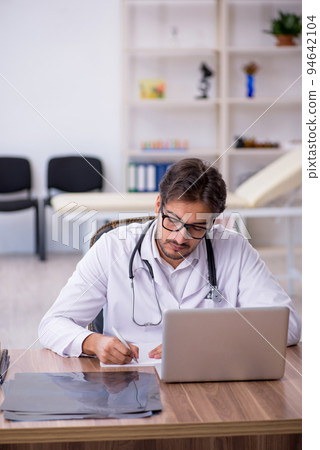 Young male doctor working in the clinic Young male doctor working in the clinic 94642104