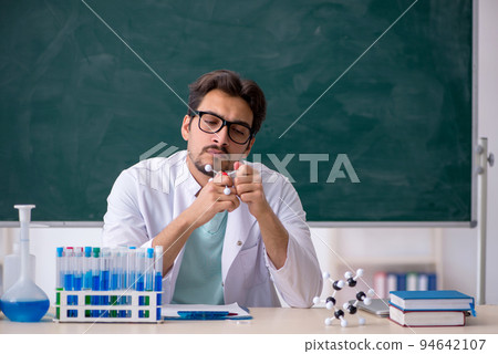 Young male chemist in front of blackboard 94642107