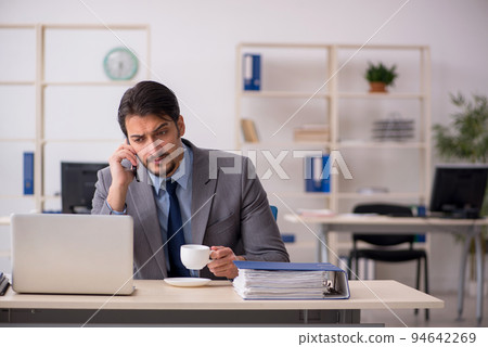 Young male employee drinking coffee during break 94642269