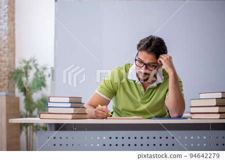 Young male student preparing for exams in the classroom Young male student preparing for exams in the classroom 94642279