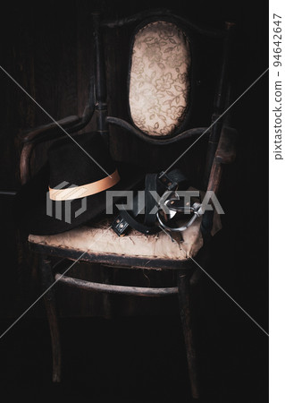 Vintage old broken wooden chair with hat, sword, bugle, books Vintage old broken wooden chair with hat, sword, bugle, books 94642647