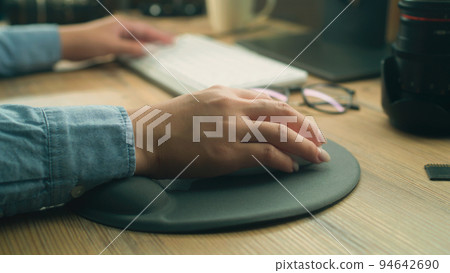 Woman working remotely on pc using mouse 94642690