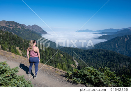 Young woman hiker observing cloud inversion in Olympic National Park, WA. 94642866