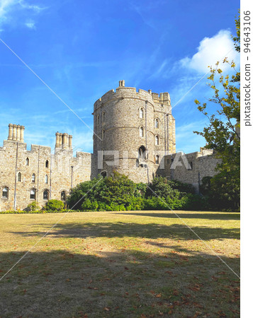 Exterior view of Windsor Castle with stone and columnar building, official residence of the British royal family, blue sky and lawns 94643106