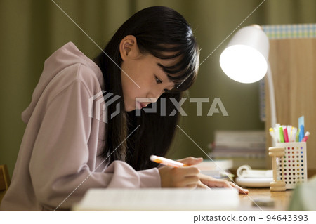 一個在書桌上學習的女孩初中高中生 94643393