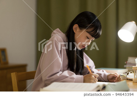 一個在書桌上學習的女孩初中高中生 94643394