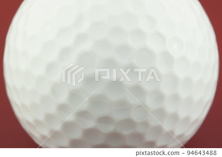 golf ball closeup on red surface 94643488