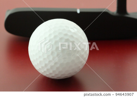 golf ball on red surface and club 94643907