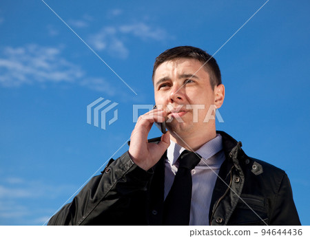 man on mobile phone on natural blue background man on mobile phone on natural blue background 94644436