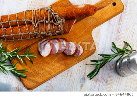 Sliced half-smoked sausages on wooden table Sliced half-smoked sausages on wooden table 94644965