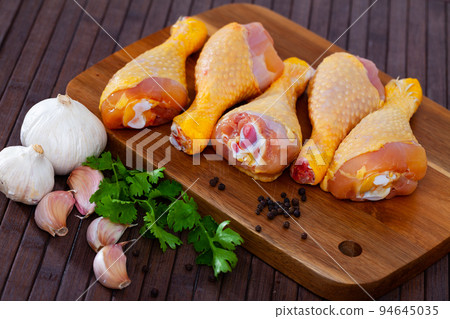 Raw chicken legs on wooden table 94645035