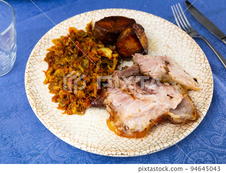 Baked pork meat with potatoes and stewed cabbage 94645043