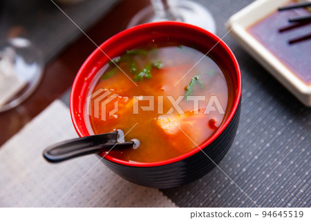 Spicy asian tomato soup in red bowl Spicy asian tomato soup in red bowl 94645519