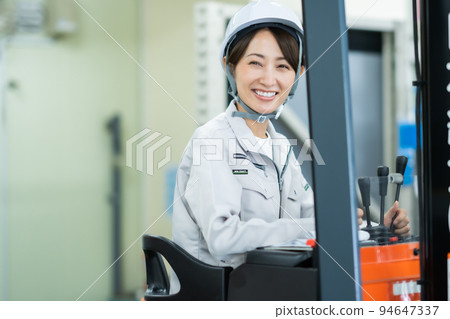 Female staff driving a forklift 94647337