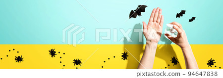 Applying sanitizer gel with Halloween theme 94647838