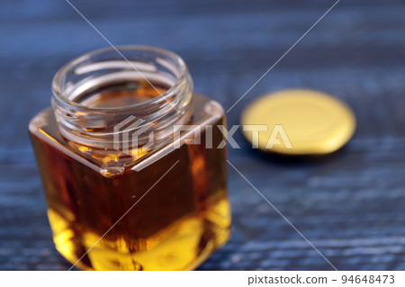 Royal jelly-filled beauty honey in a jar on the table Royal jelly-filled beauty honey in a jar on the table 94648473