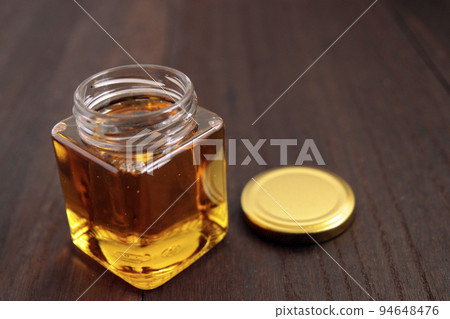 桌上的罐子裡裝滿蜂王漿的美容蜂蜜 桌上的罐子裡裝滿蜂王漿的美容蜂蜜 94648476
