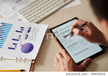 Close-up image of businessman writing personal data in application form on digital tablet Close-up image of businessman writing personal data in application form on digital tablet 94648836