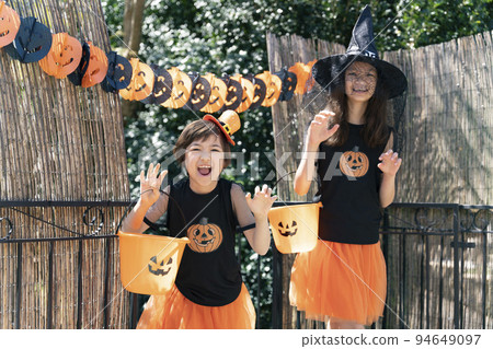 兩個穿著萬聖節服裝的女孩在玩搗蛋或款待 94649097