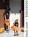 兩個女孩在用萬聖節服裝裝飾的房子門前 94649099