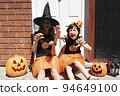 兩個女孩在用萬聖節服裝裝飾的房子門前 94649100
