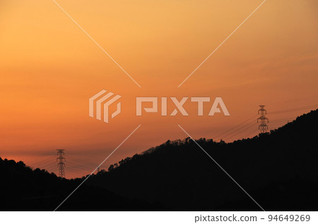 夕陽染紅的天空和電線 94649269