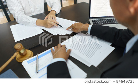 Lawyer and legal concept, Senior lawyer pointing to contract while explaining detail to businessman Lawyer and legal concept, Senior lawyer pointing to contract while explaining detail to businessman 94649725