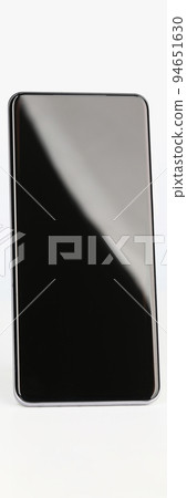 Black smartphone stands upright on a white background Black smartphone stands upright on a white background 94651630