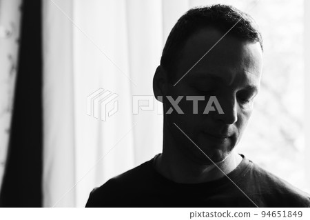Dark studio portrait of young sad Caucasian man Dark studio portrait of young sad Caucasian man 94651849