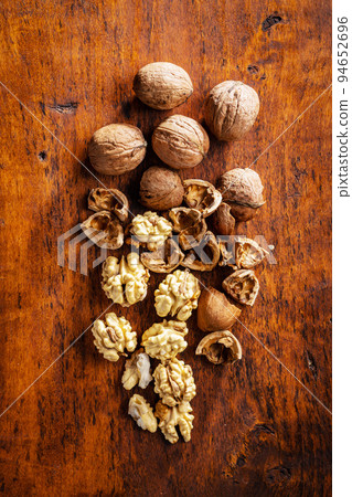 Peeled walnut on wooden table. 94652696
