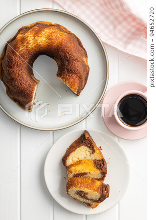 Sweet sponge cake. Bundt cake on plate on white table. 94652720