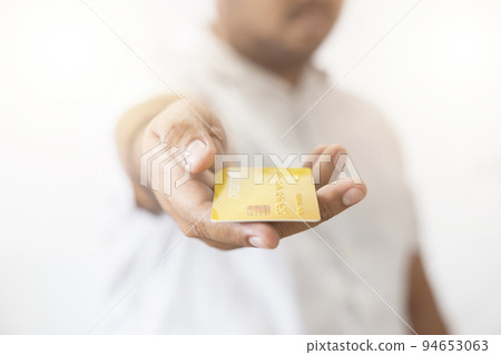 Close-up hand of Asian man holding yellow gold credit card in his hand. isolated on white background. Concept of finance, trading, communication, social, technology, business Close-up hand of Asian man holding yellow gold credit card in his hand. isolated on white background. Concept of finance, trading, communication, social, technology, business 94653063