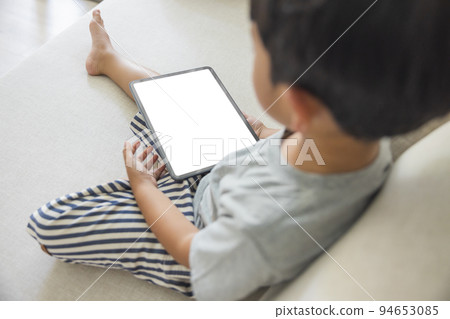 Close-up adorable happy Asian boy hand held use finger touches with digital tablet white screen isolated on white background. Concept of technology, connection, communication, social. Close-up adorable happy Asian boy hand held use finger touches with digital tablet white screen isolated on white background. Concept of technology, connection, communication, social. 94653085