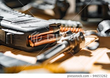 Black disassembled shotgun and cleaning tools on wooden table . Black disassembled shotgun and cleaning tools on wooden table . 94653262
