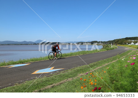 A cyclist running on the Tsukuba Kasumigaura Rinrin Road A cyclist running on the Tsukuba Kasumigaura Rinrin Road 94653333