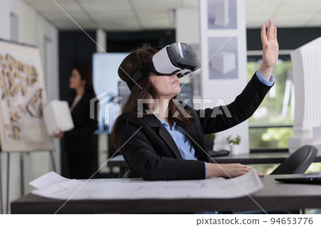 Architect in ar helmet touching virtual building model, working on project in metaverse. Employee engineering in virtual reality, real estate agency worker in vr headset in architecture office Architect in ar helmet touching virtual building model, working on project in metaverse. Employee engineering in virtual reality, real estate agency worker in vr headset in architecture office 94653776