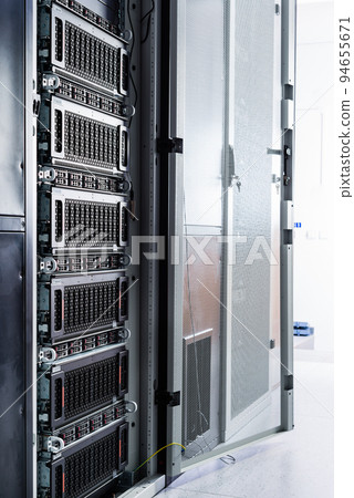 A row of racks with data storage hardware inside server room 94655671