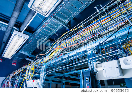 detail of large number of ethernet cables tied together connecting racks inside server room 94655673
