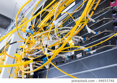 yellow fiber optic cables plugged in network switch 94655748