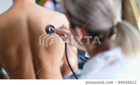Young doctor examines the patient lungs with stethoscope 94656022