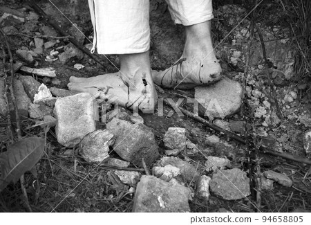 Wounded feet walk a hard rocky path Wounded feet walk a hard rocky path 94658805